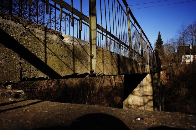 A dilapidated bridge in need of repair, symbolizing the infrastructure challenges faced by many local governments in the US. The image highlights the neglect and urgent need for investment in infrastructure projects.
