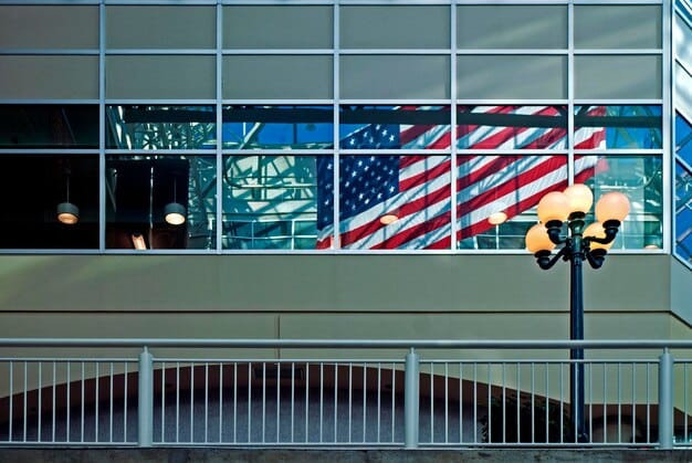 The exterior of a local city hall building with the American flag waving in front. People are entering the building, presumably for a public hearing or government meeting.