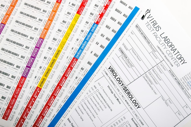 A detailed risk assessment form being filled out by two event organizers. The form includes sections for identifying potential hazards (e.g., weather, crowd surge, equipment malfunction), assessing the likelihood and severity of each hazard, and outlining mitigation strategies. The background shows a busy event planning office with various event-related documents and equipment.