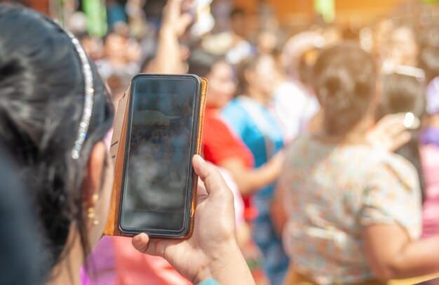 Attendees at a community festival using an event-specific mobile app to navigate the venue, view schedules, and participate in interactive polls, showcasing the role of technology in enhancing engagement.