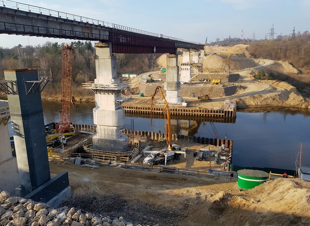 A construction site where a new water treatment plant is being built. The image should emphasize the scale and complexity of the project, with workers operating heavy machinery and erecting large concrete structures, reflecting the infrastructure investments related to The Impact of the Infrastructure Bill on the Construction Industry: New Projects and Opportunities.