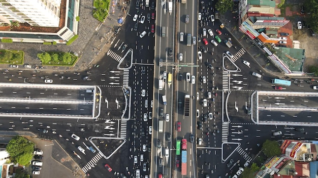 Aerial view of a busy highway intersection with multiple lanes of traffic, showing cars and trucks moving in different directions. The image highlights the complexity of modern transportation infrastructure and the need for improvements. The phrase 